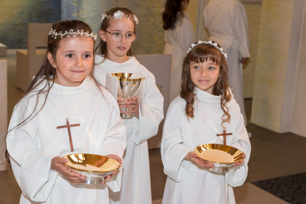 Erstkommunionkinder bringen die Hostien zum Altar